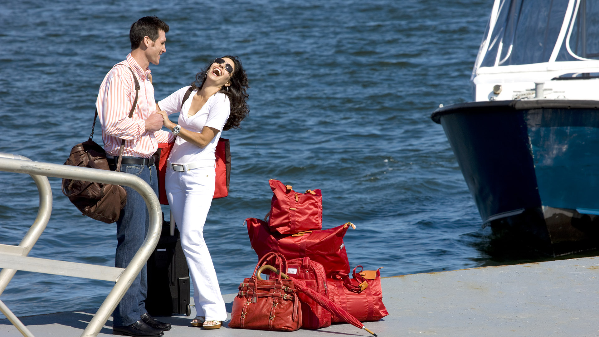 twenty two liberty couple on dock with red bags with boat in bacgkround