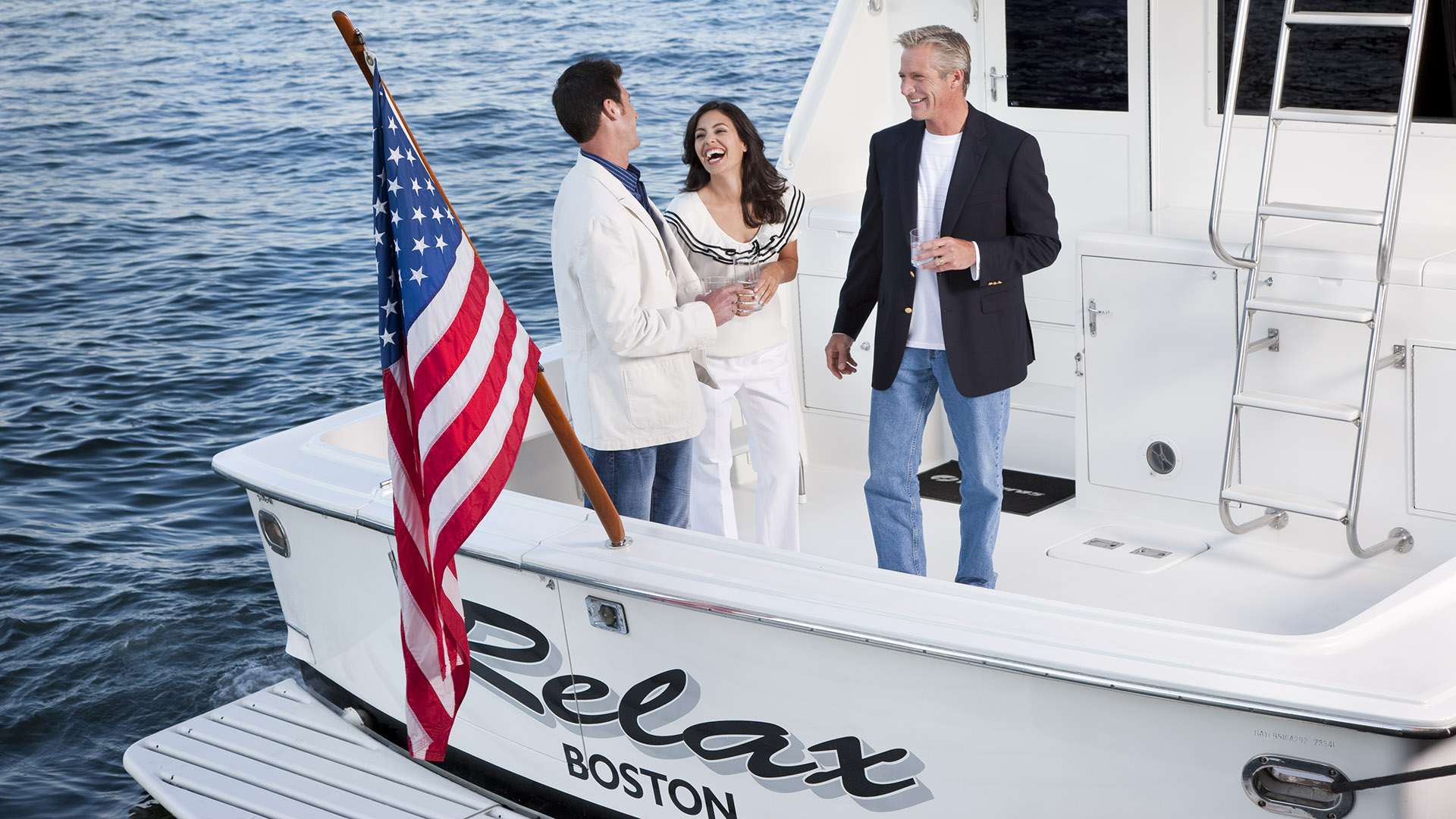 twenty two liberty people on back of yacht with american flag