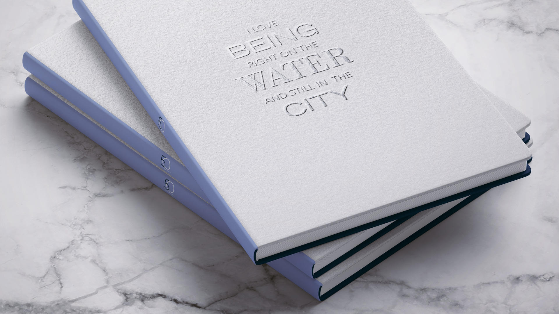 50 liberty white embossed cover with stack of print brochures