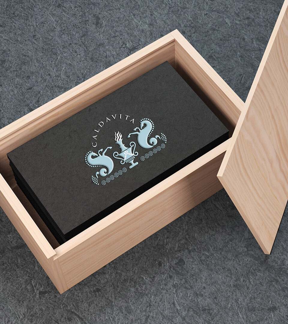 calda vita black business card sitting inside wooden box