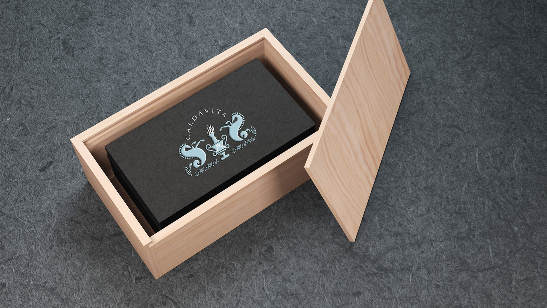 calda vita black business card sitting inside wooden box