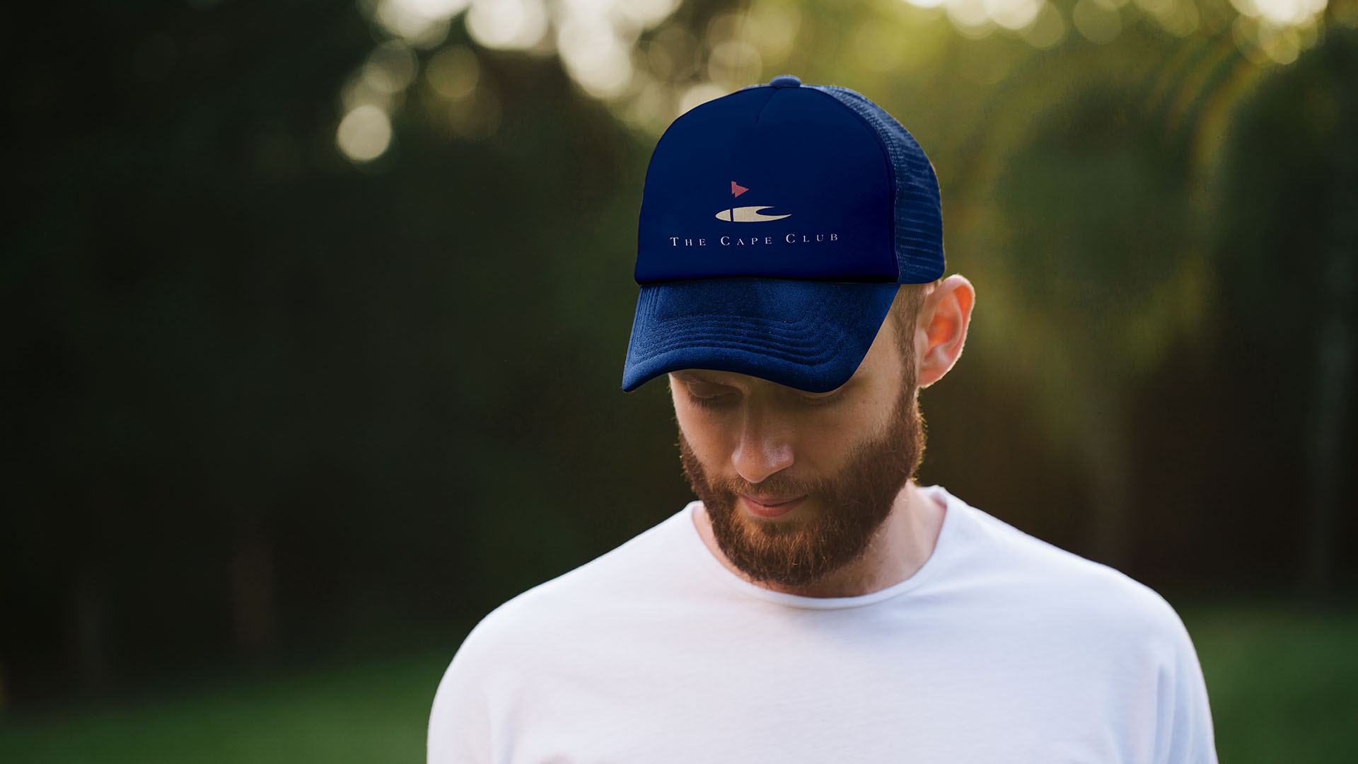 cape club logo on blue hat with man in white t shirt