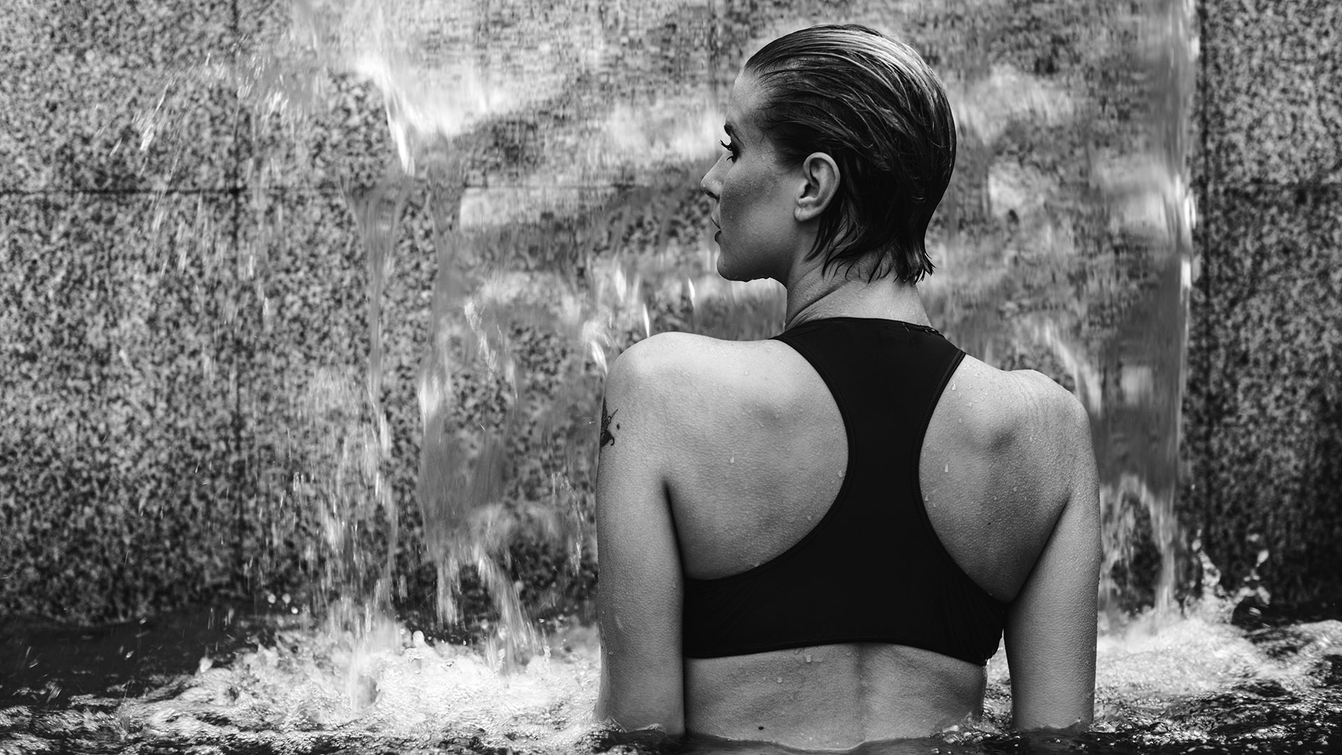 echelon seaport black and white photo of woman in pool with waterfall