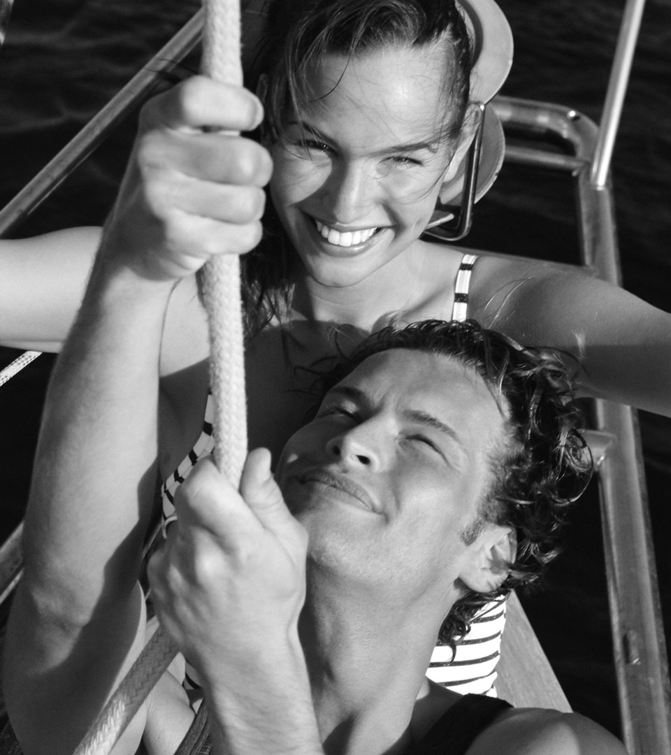mirabelle bay black and white photo of young woman and man pulling up sail for home