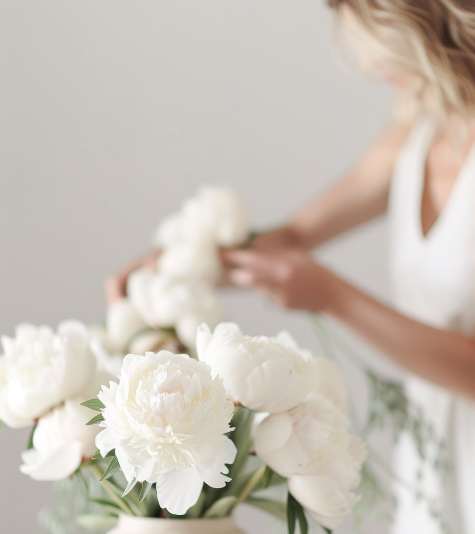 one dalton woman putting white flowers in white vase