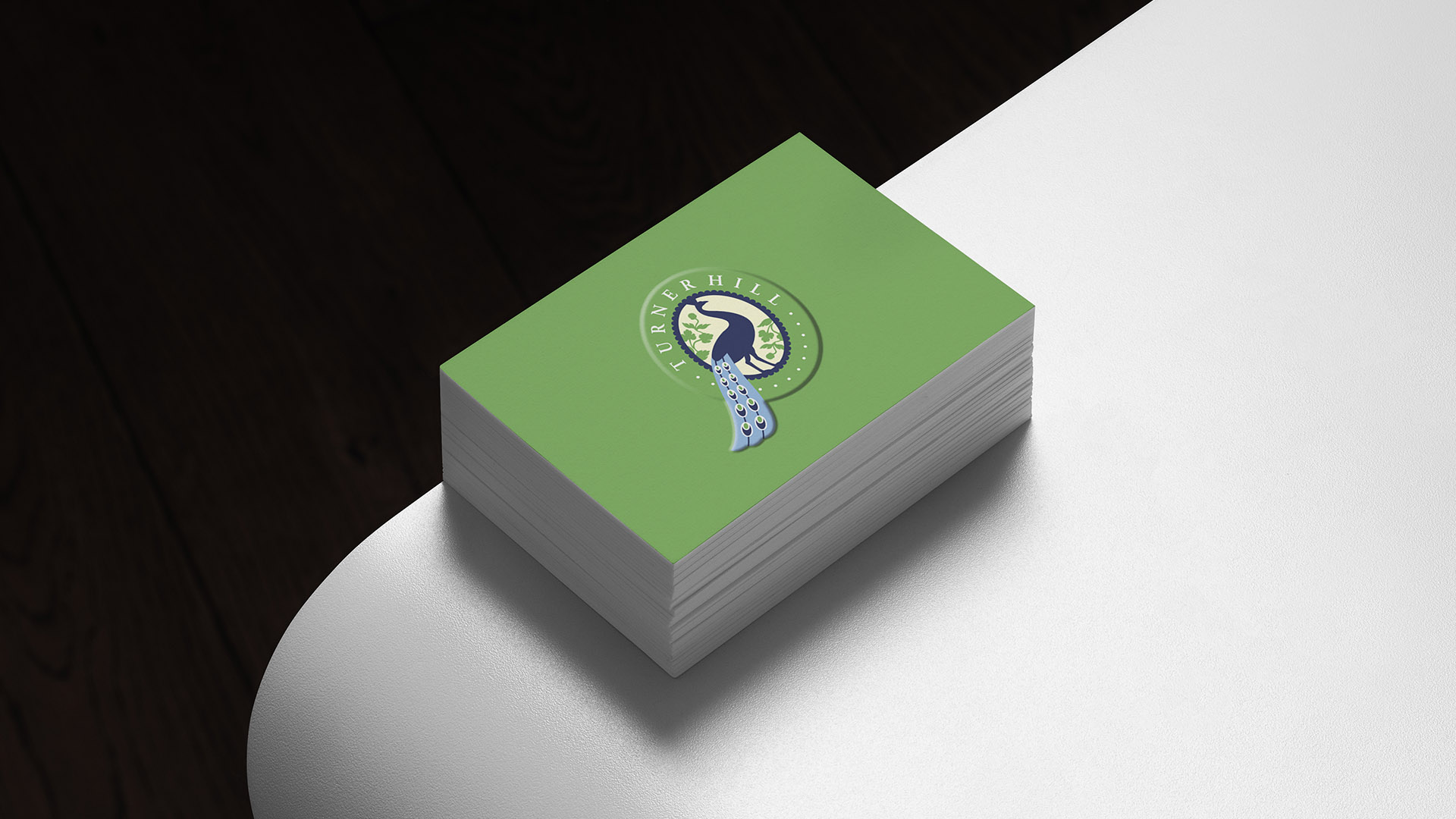 turner hill green embossed business card on white table